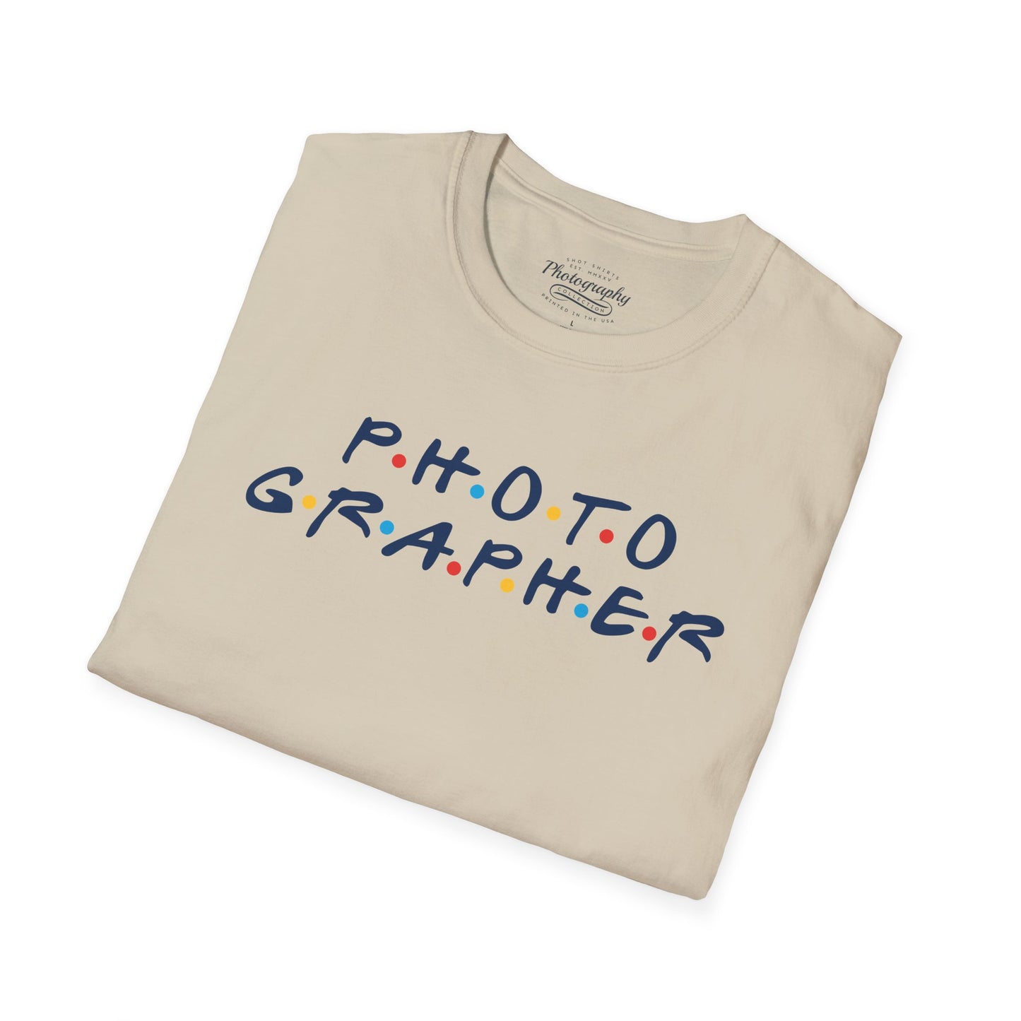 Folded beige t-shirt with 'PHOTOGRAPHER' text in colorful letters on a white background