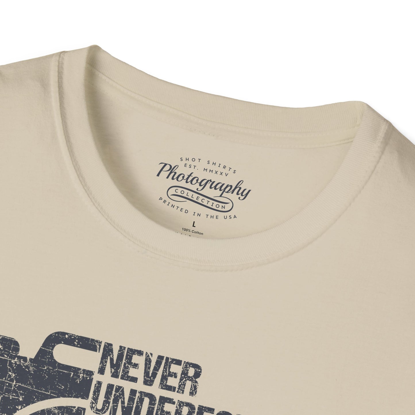 Sand t-shirt with 'Never Underestimate' graphic and brand text on a white background