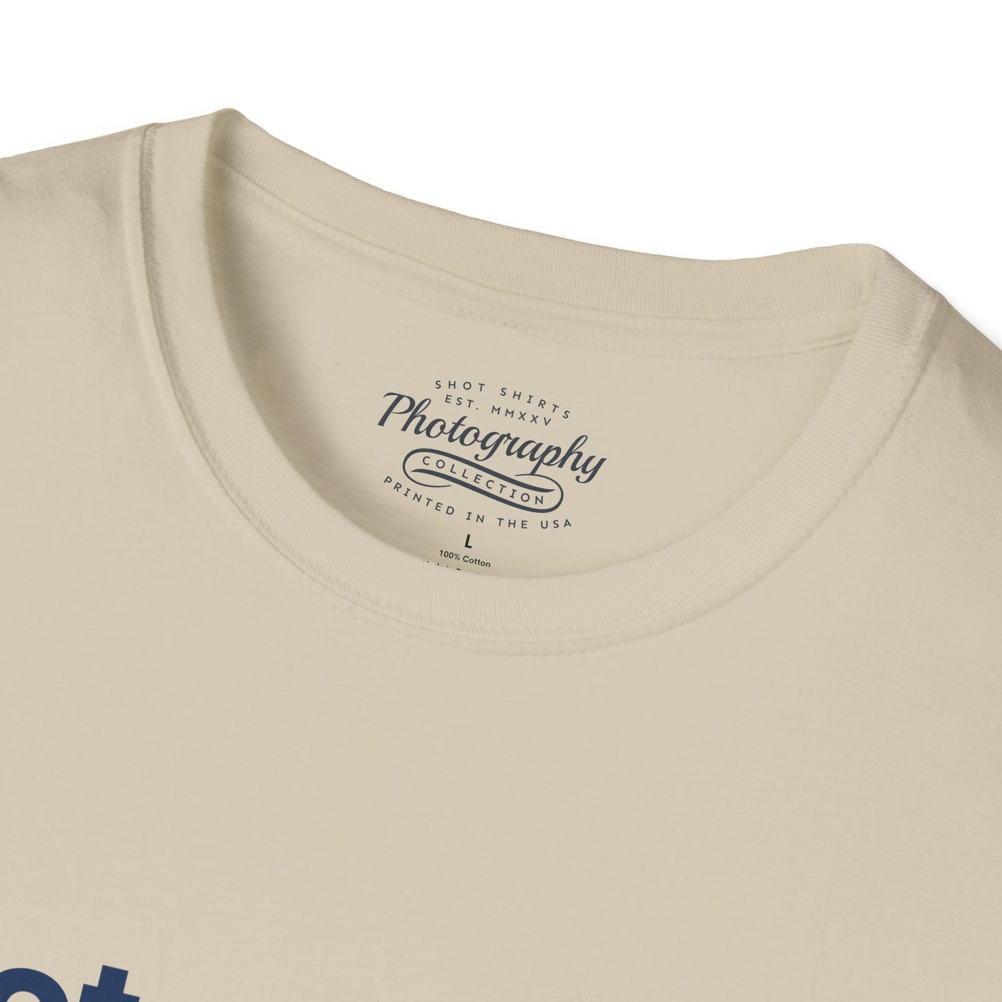 Close-up of a beige t-shirt with a photography-themed label on the collar.