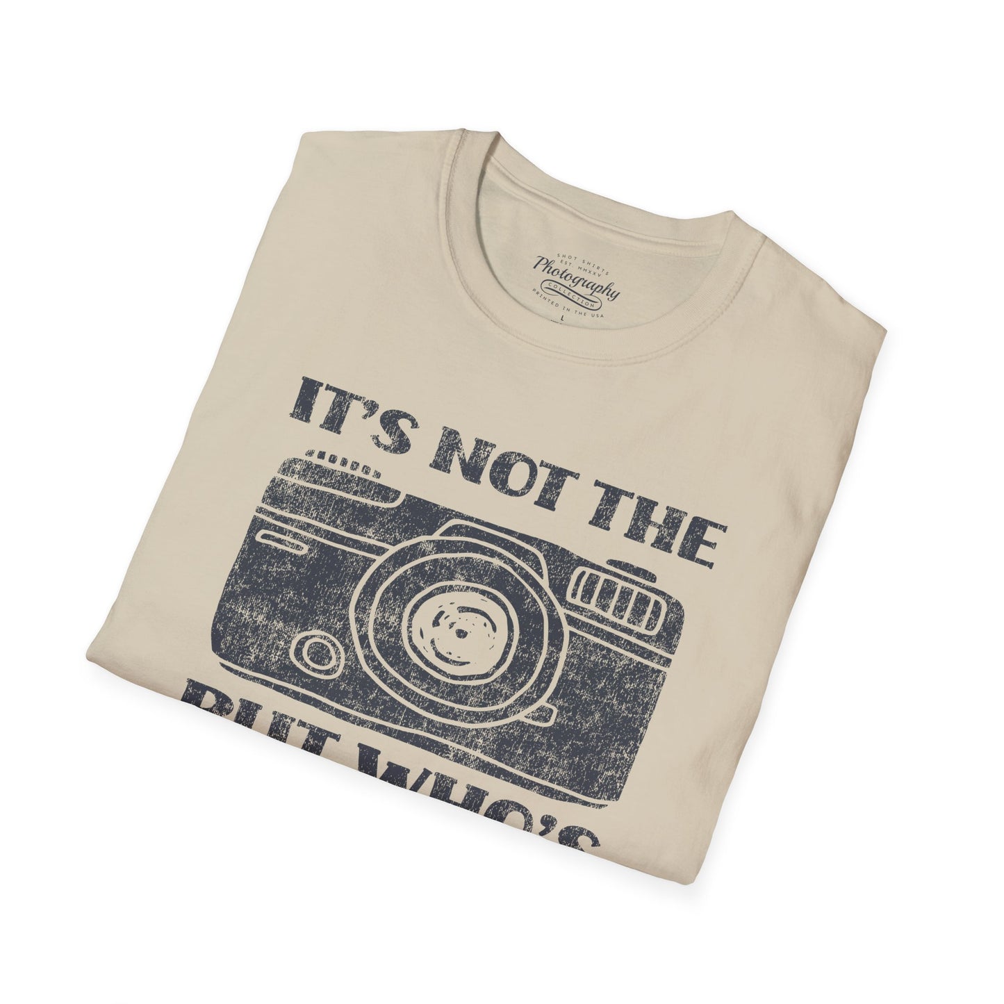 Folded beige t-shirt with camera graphic and text on a white background