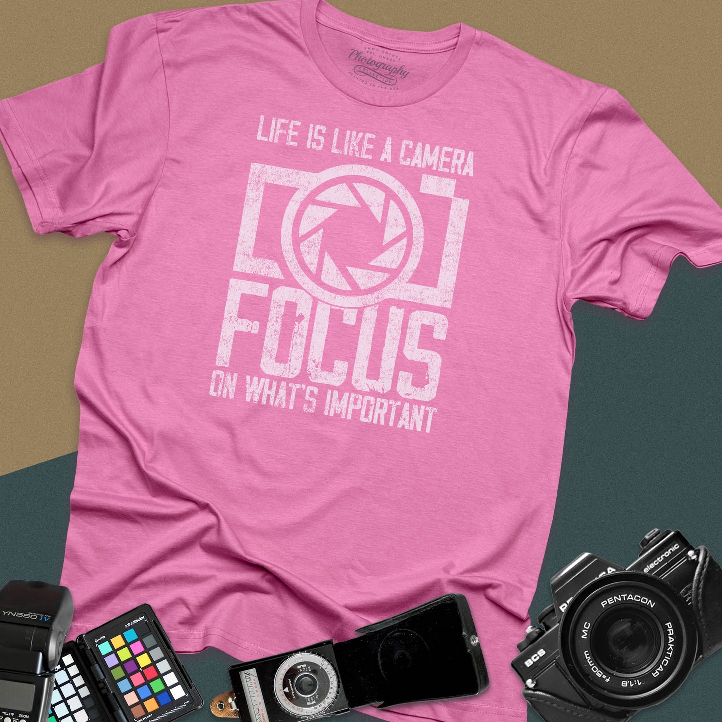 Distressed azalea t-shirt featuring a large retro camera silhouette with an aperture shutter lens graphic and inspirational photography quote typography.