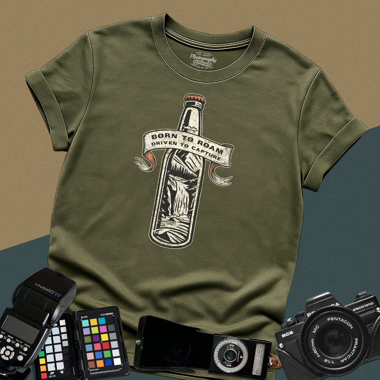 Vintage military-green graphic t-shirt featuring a bottle with a mountain landscape and the text "Born to Roam Driven to Capture" for travel photographers.