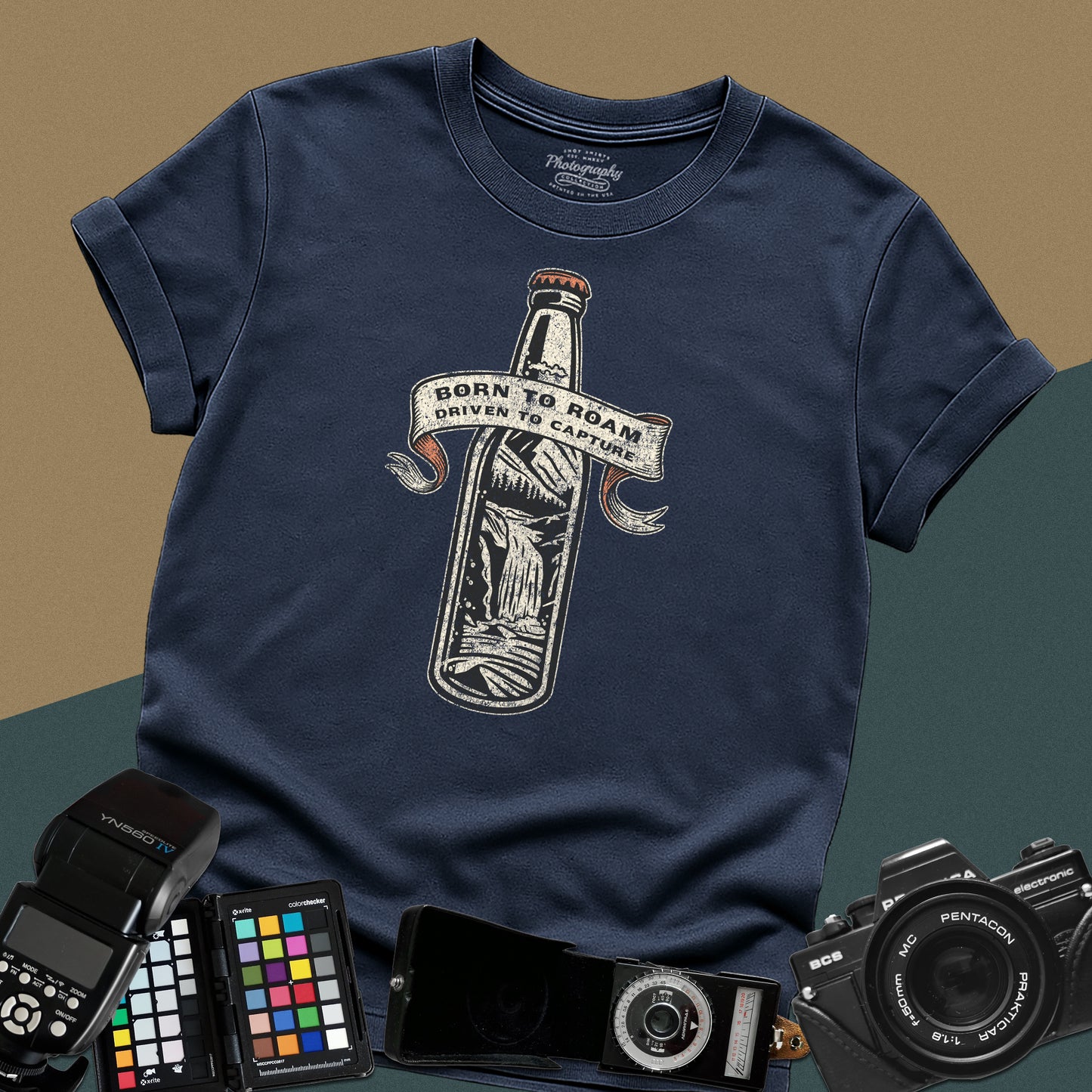 Vintage navy-blue graphic t-shirt featuring a bottle with a mountain landscape and the text "Born to Roam Driven to Capture" for travel photographers.