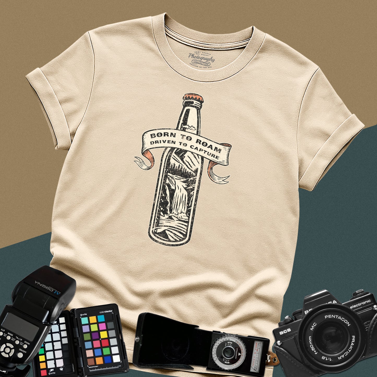 Vintage sand graphic t-shirt featuring a bottle with a mountain landscape and the text "Born to Roam Driven to Capture" for travel photographers.