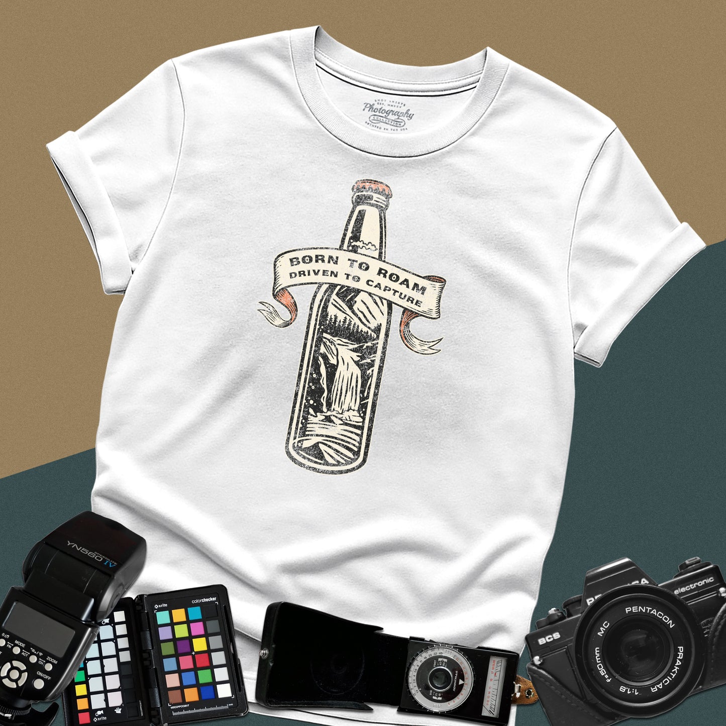 Vintage white graphic t-shirt featuring a bottle with a mountain landscape and the text "Born to Roam Driven to Capture" for travel photographers.