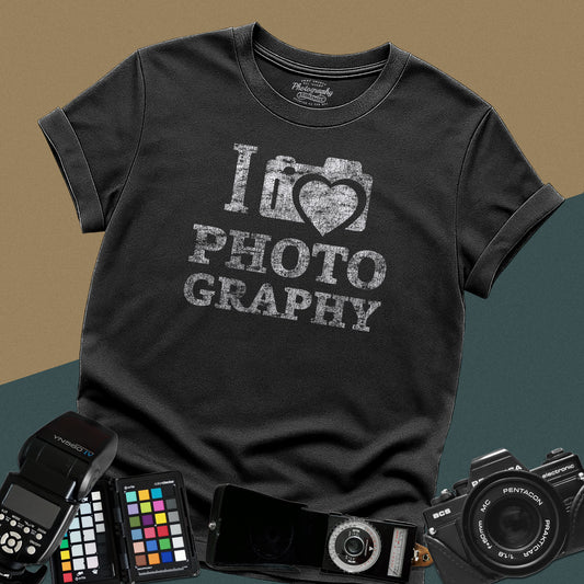 Heavy distressed black t-shirt featuring a retro camera icon with an integrated heart silhouette and bold split typography text "I Love Photography".