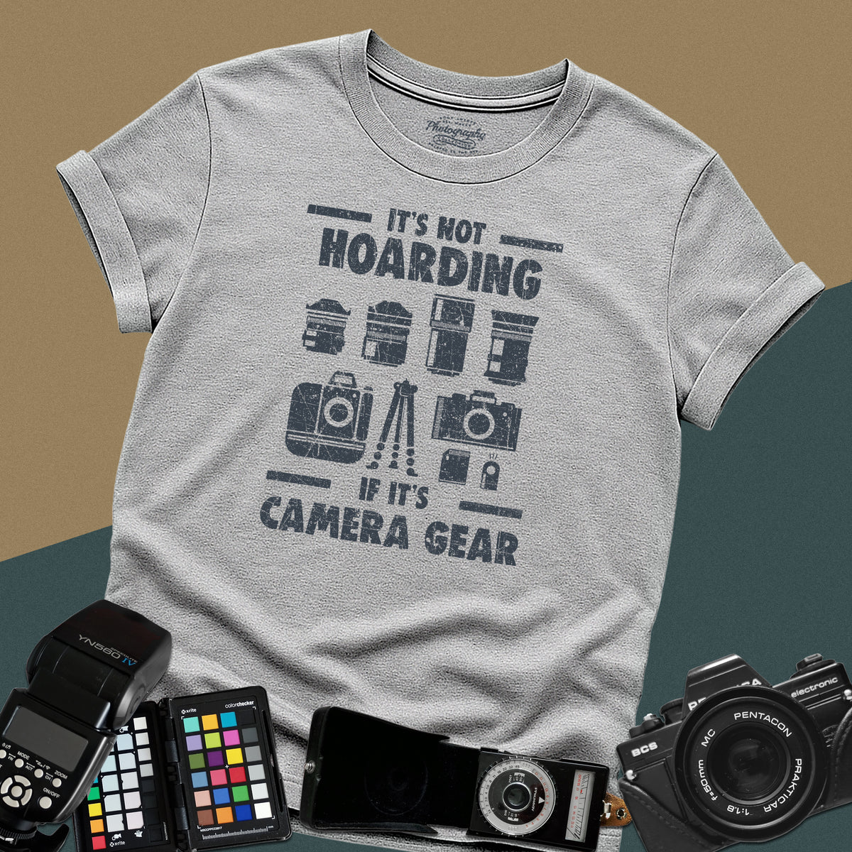 A sport-grey t-shirt featuring a distressed graphic with illustrations of camera bodies, lenses, and a tripod between the text "IT'S NOT HOARDING" and "IF IT'S CAMERA GEAR."
