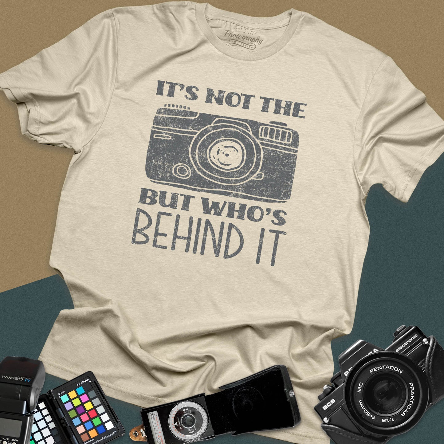 Distressed sand t-shirt featuring a vintage rangefinder camera illustration with a bold retro typography quote for professional visual creators.