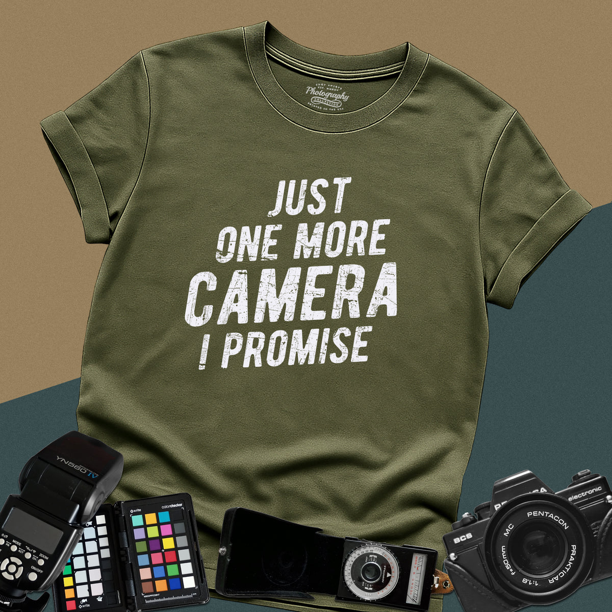A military-green t-shirt featuring a distressed typography design that reads "JUST ONE MORE CAMERA I PROMISE" in bold letters across the chest.