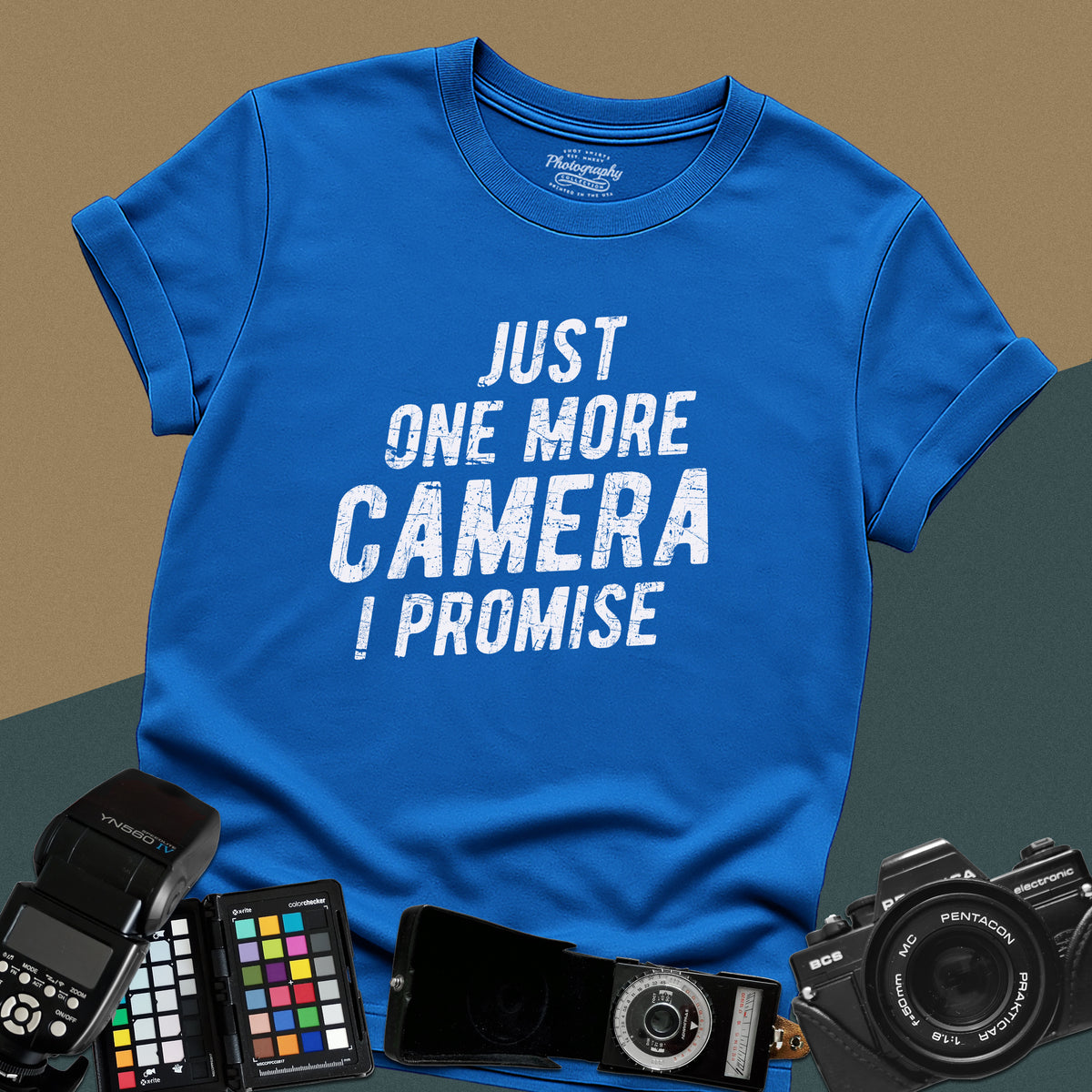 A royal-blue t-shirt featuring a distressed typography design that reads "JUST ONE MORE CAMERA I PROMISE" in bold letters across the chest.