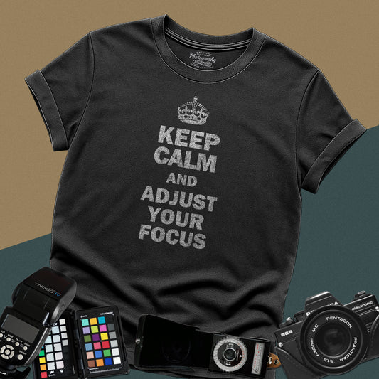 Distressed black t-shirt featuring the vintage blue text Keep Calm and Adjust Your Focus with a crown icon for professional camera lovers.