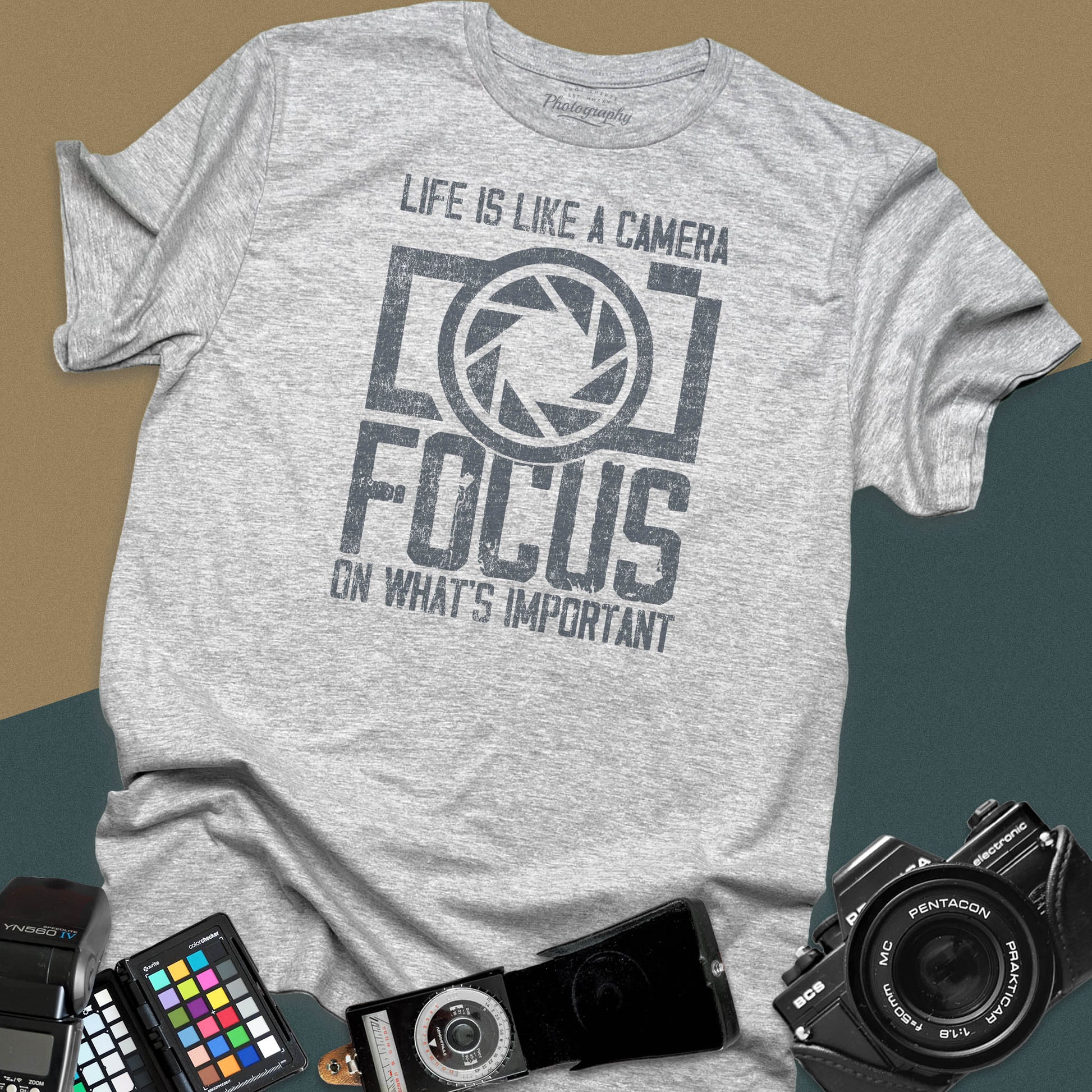 Distressed sport-grey t-shirt featuring a large retro camera silhouette with an aperture shutter lens graphic and inspirational photography quote typography.