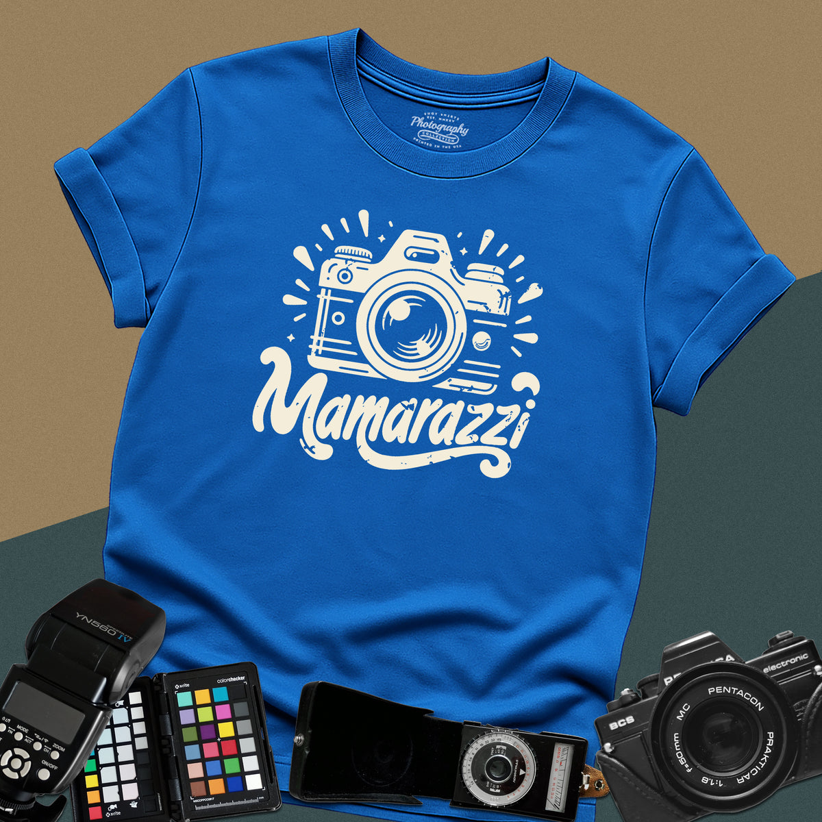 A royal-blue t-shirt featuring a distressed vintage camera graphic with sparkles and the stylized text "Mamarazzi" written in a retro script font across the chest.