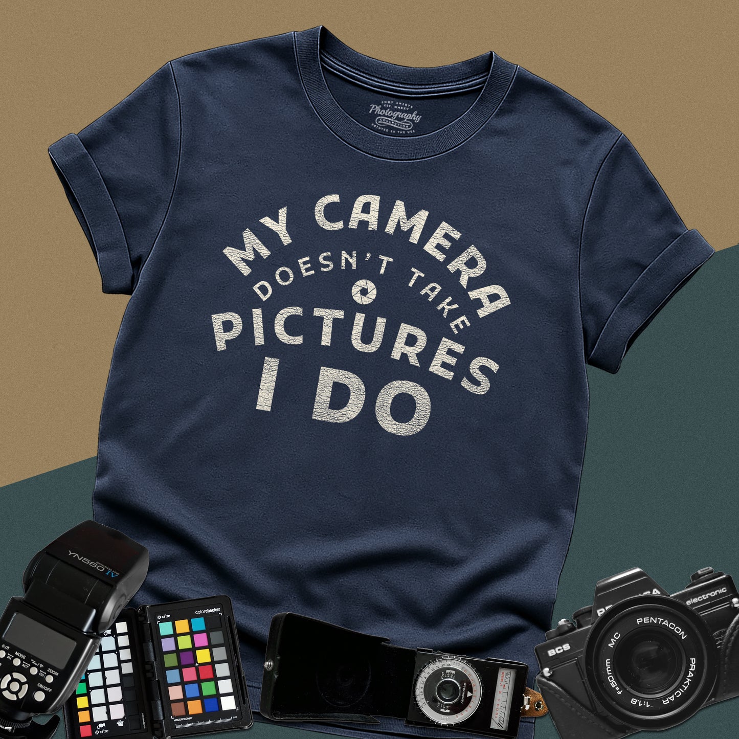 Minimalist navy-blue t-shirt featuring the arched vintage text "My Camera Doesn't Take Pictures I Do" with an aperture icon for photographers.