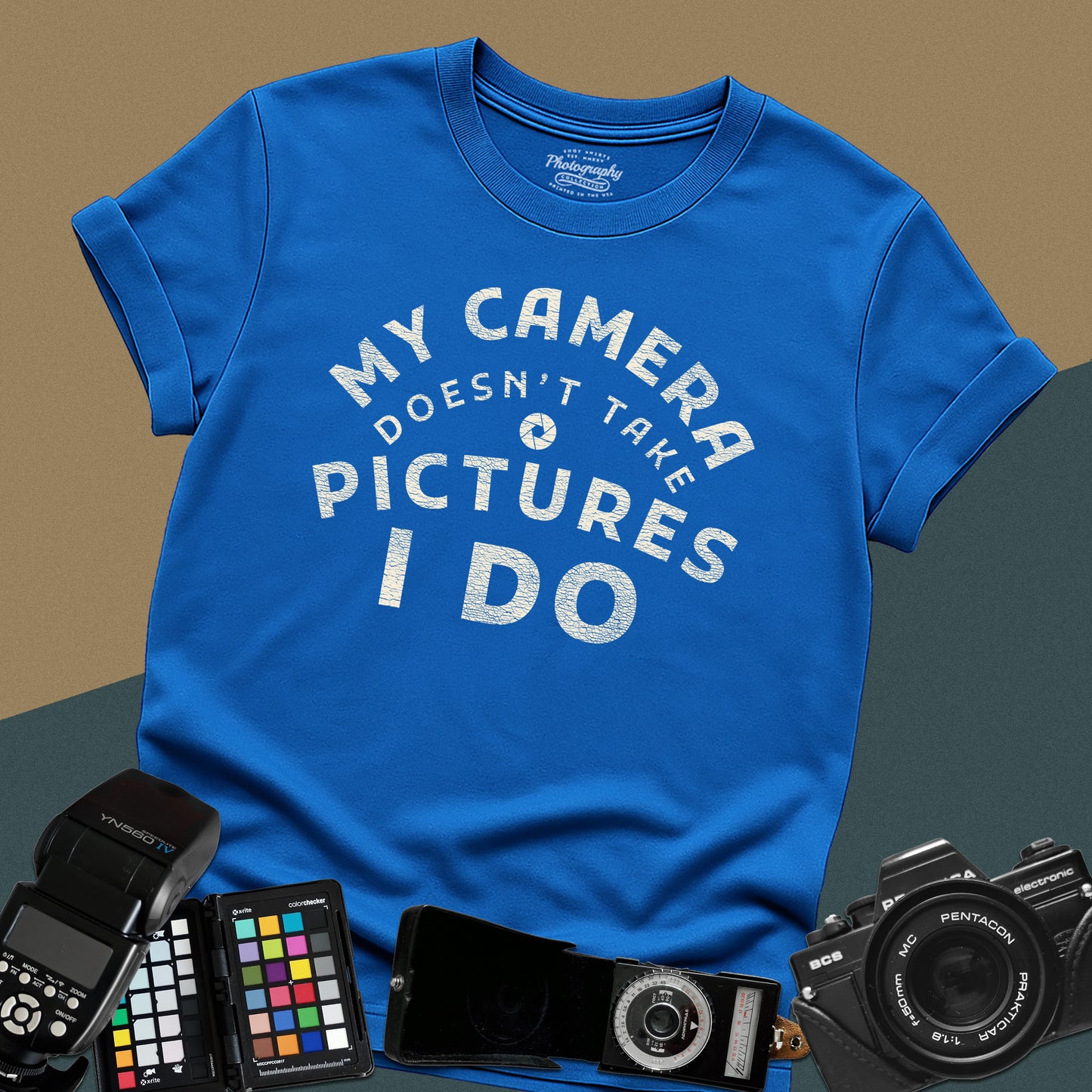 Minimalist royal-blue t-shirt featuring the arched vintage text "My Camera Doesn't Take Pictures I Do" with an aperture icon for photographers.