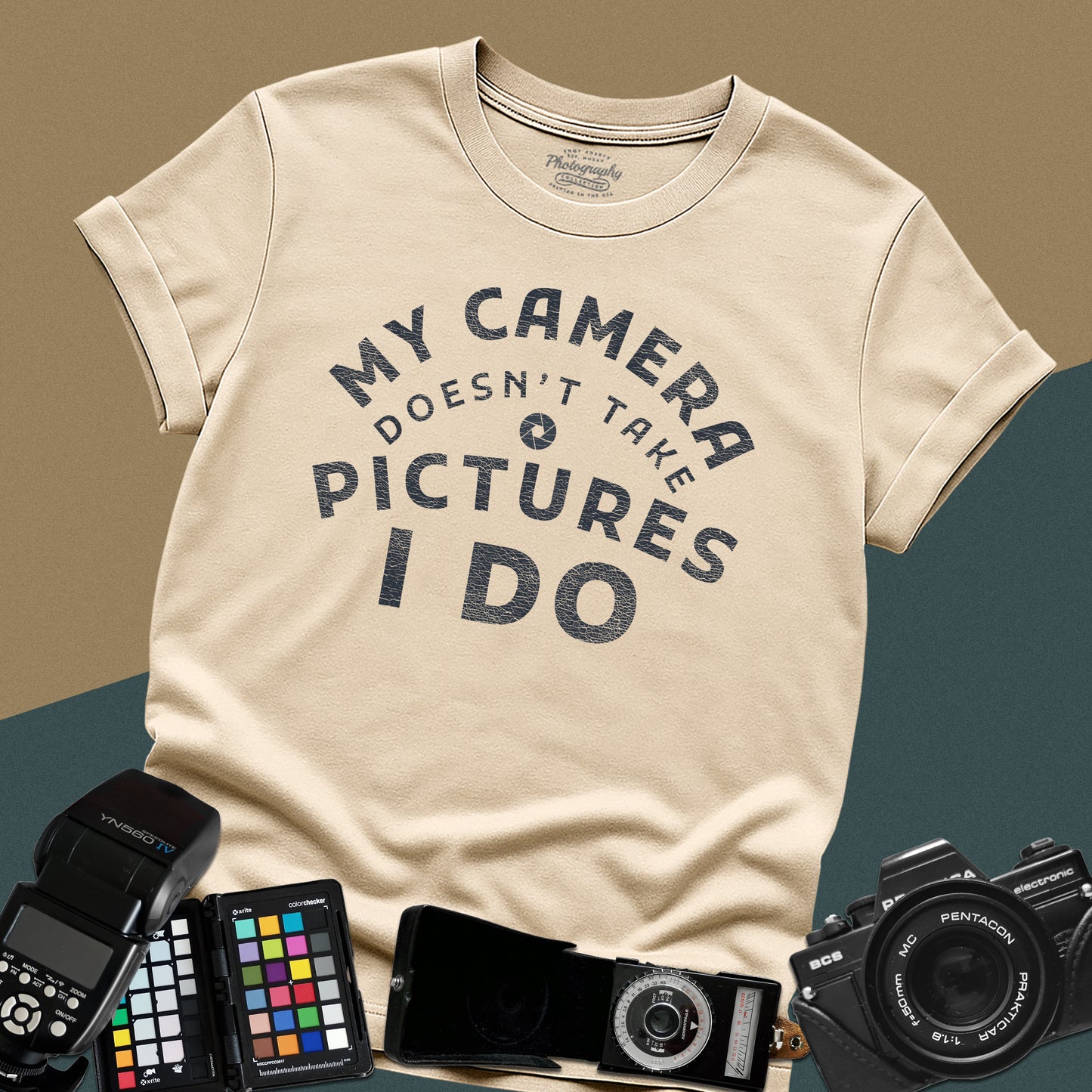 Minimalist sand t-shirt featuring the arched vintage text "My Camera Doesn't Take Pictures I Do" with an aperture icon for photographers.