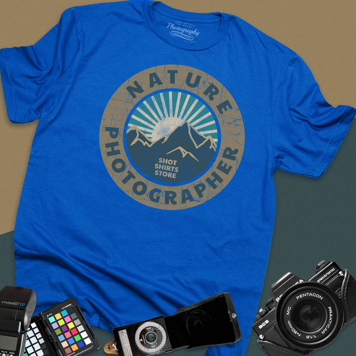 A royal blue t-shirt featuring a circular distressed retro graphic with mountains and a sunburst, with the words "Nature Photographer" arced around the top and bottom.
