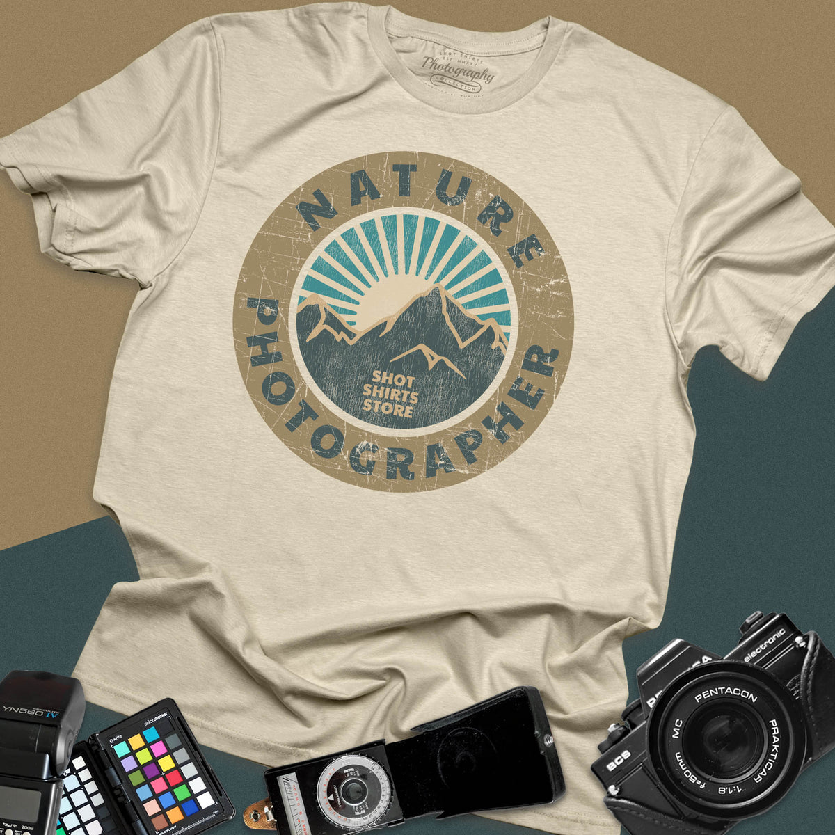 A sand t-shirt featuring a circular distressed retro graphic with mountains and a sunburst, with the words "Nature Photographer" arced around the top and bottom.