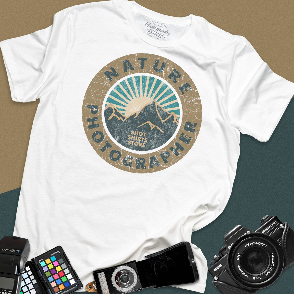 A white t-shirt featuring a circular distressed retro graphic with mountains and a sunburst, with the words "Nature Photographer" arced around the top and bottom.