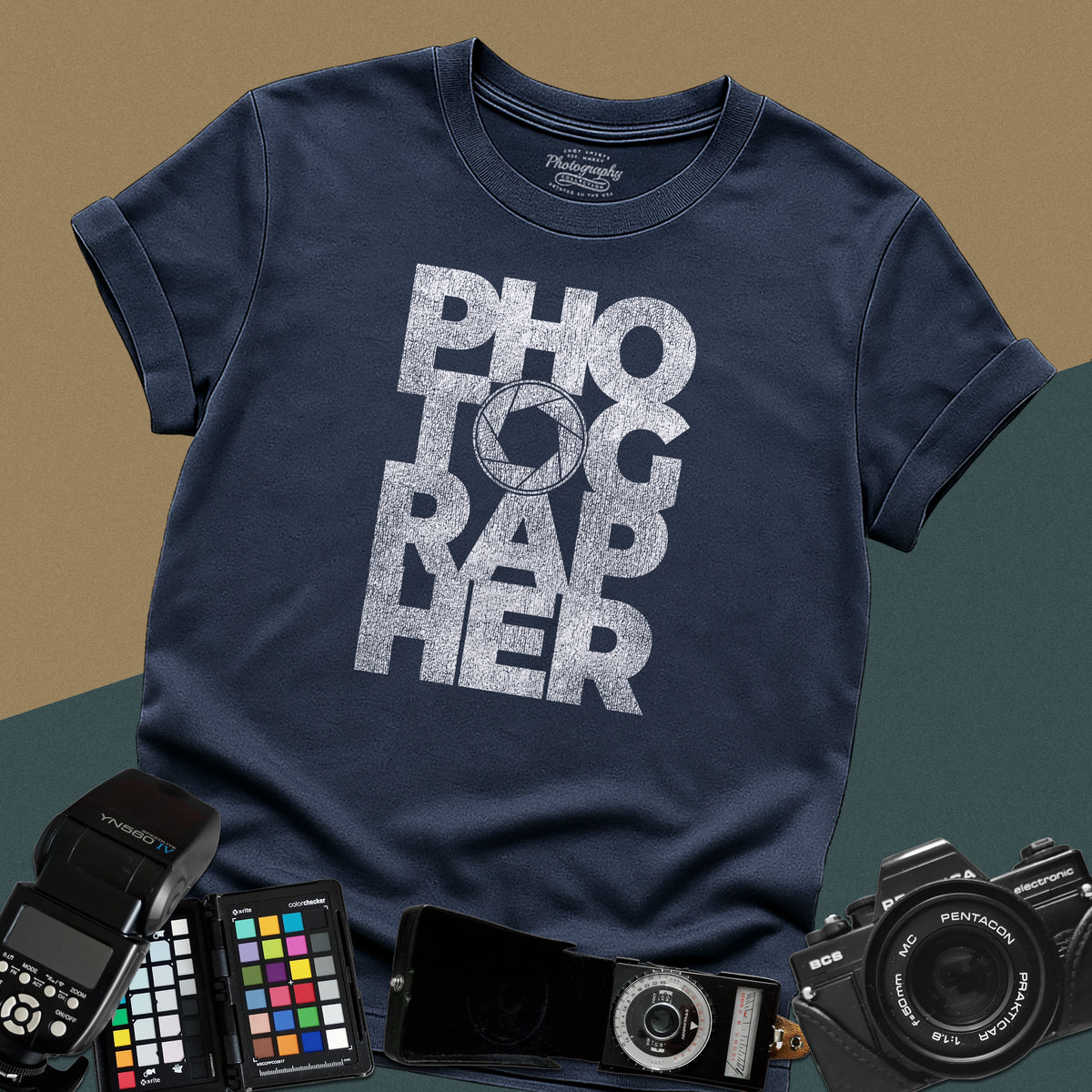 Clean navy-blue t-shirt featuring a geometric bold block typography design spelling photographer with a camera aperture lens icon inside the letter O.