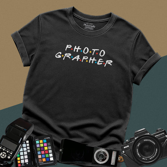 Clean black t-shirt featuring a funny photographer typography parody inspired by the classic nineties television show font with colorful dots.