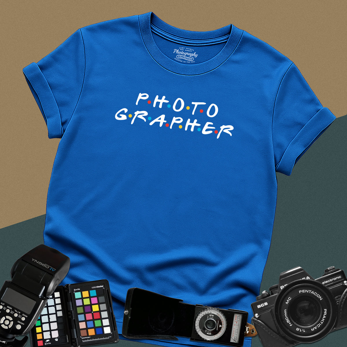 Clean royal-blue t-shirt featuring a funny photographer typography parody inspired by the classic nineties television show font with colorful dots.