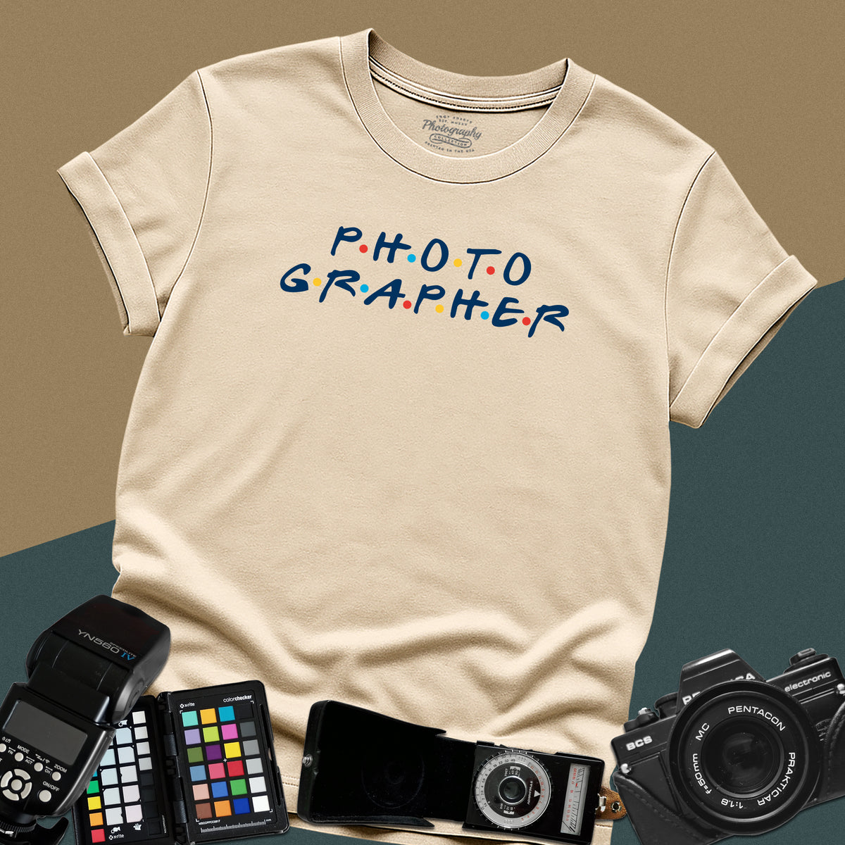 Clean sand t-shirt featuring a funny photographer typography parody inspired by the classic nineties television show font with colorful dots.