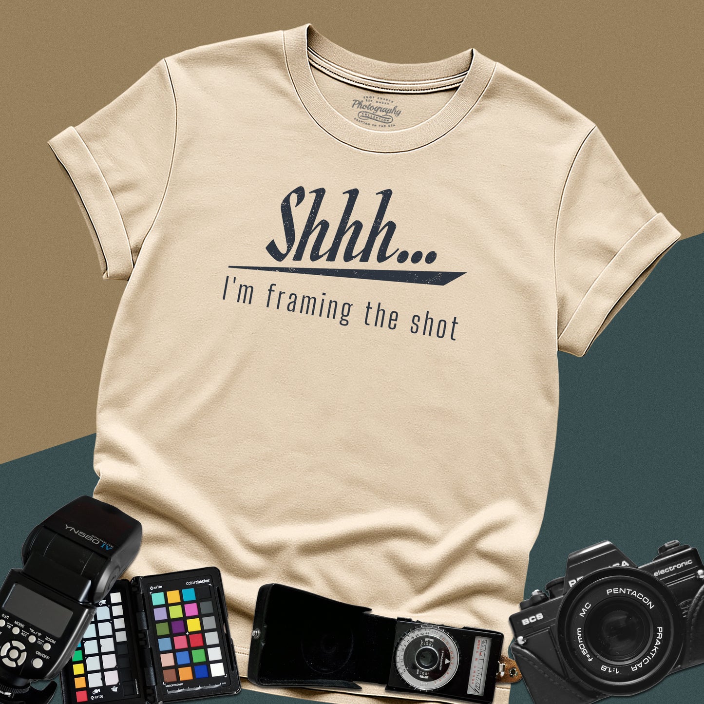 Minimalist sand t-shirt featuring the distressed vintage text "Shhh... I'm framing the shot" for professional portrait photographers.