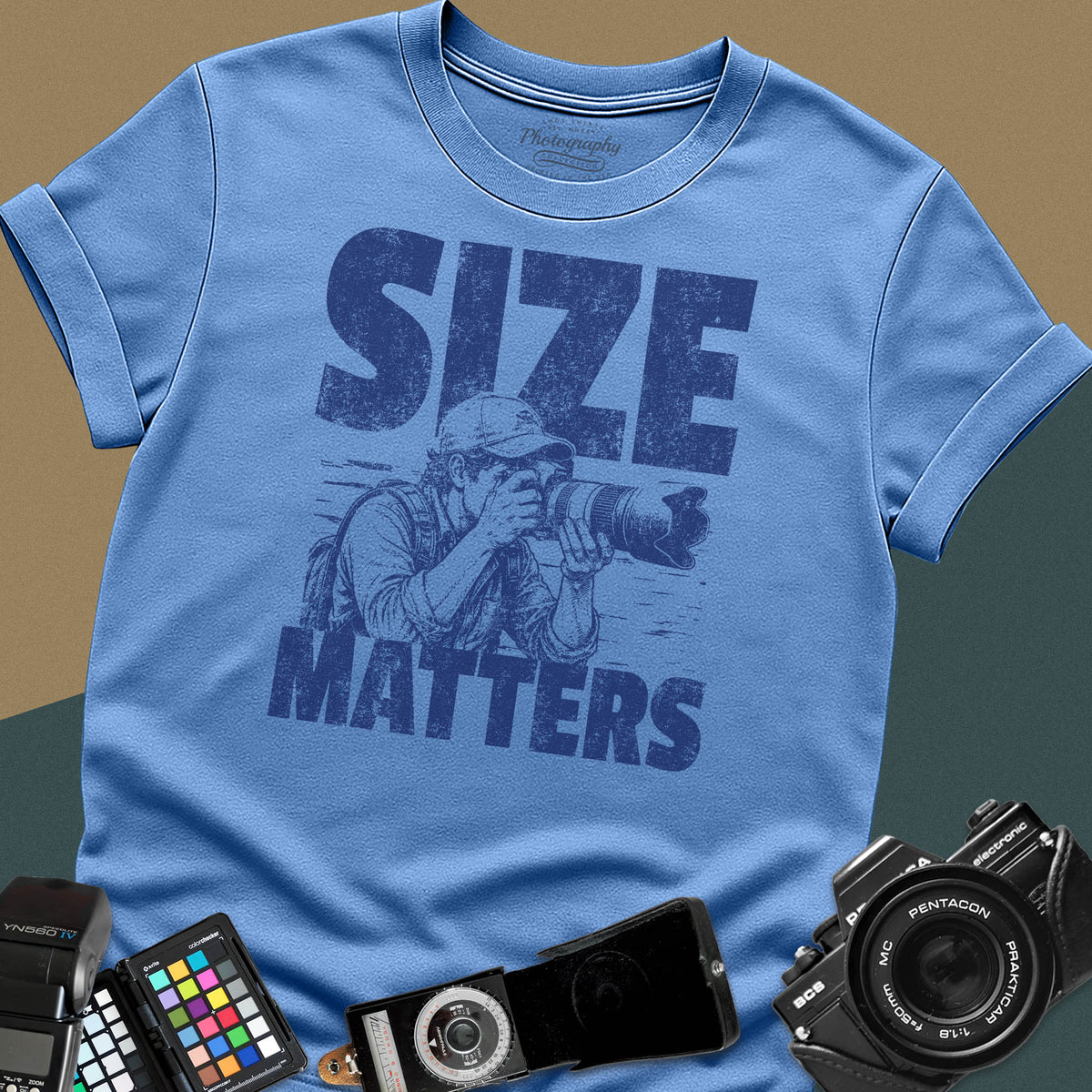 A Carolina blue t-shirt featuring a distressed graphic of a photographer looking through a camera with a huge telephoto lens, with the words "SIZE" and "MATTERS" in bold between them.
