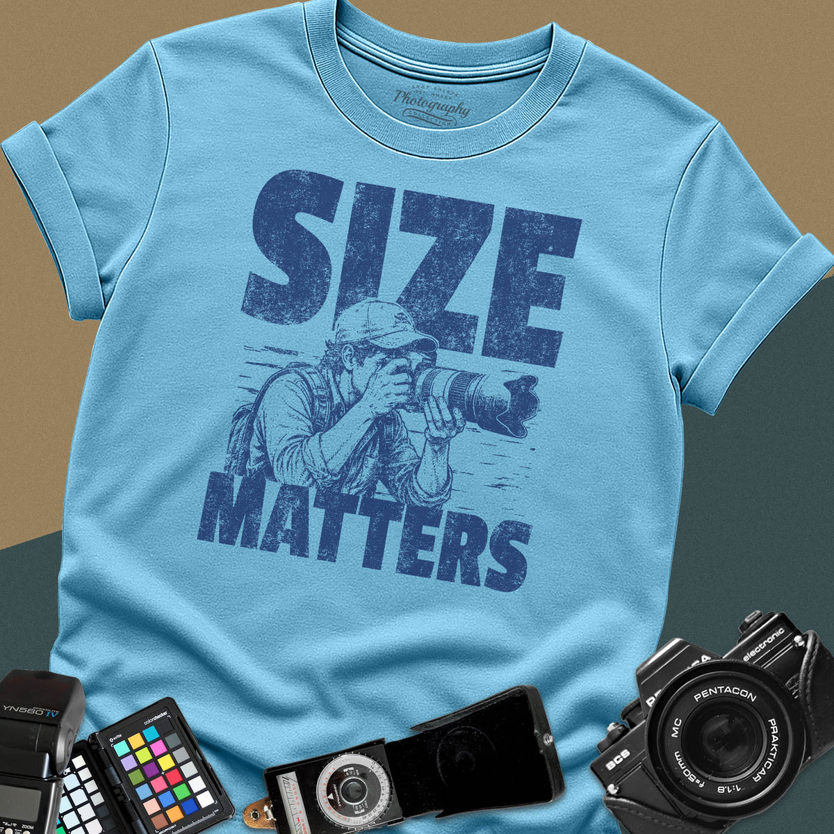 A sky-blue t-shirt featuring a distressed graphic of a photographer looking through a camera with a large telephoto lens, with the words "SIZE" and "MATTERS" in bold between them.