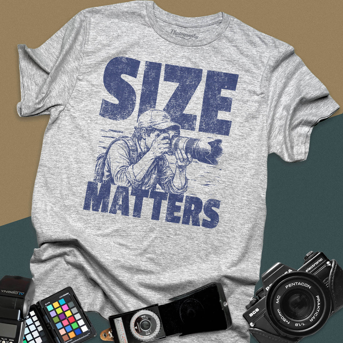 A sport grey t-shirt featuring a distressed graphic of a photographer looking through a camera with a huge telephoto lens, with the words "SIZE" and "MATTERS" in bold between them.