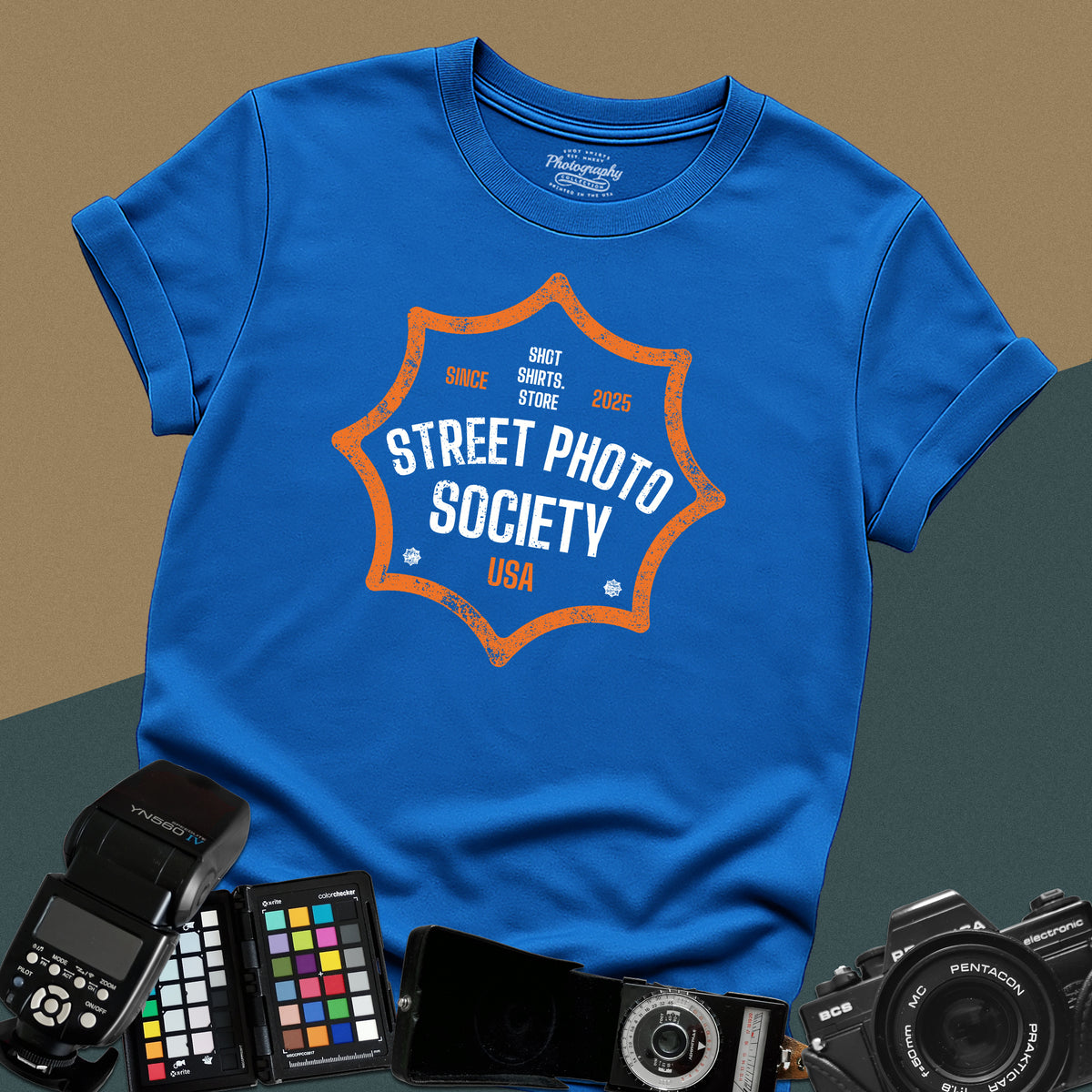 Distressed royal-blue t-shirt featuring a retro shield badge emblem with Street Photo Society USA typography for urban documentary photographers.